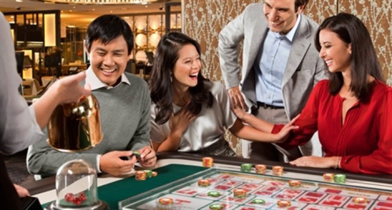 Компания азиатов в хорошем настроениее играет в сик бо в казино