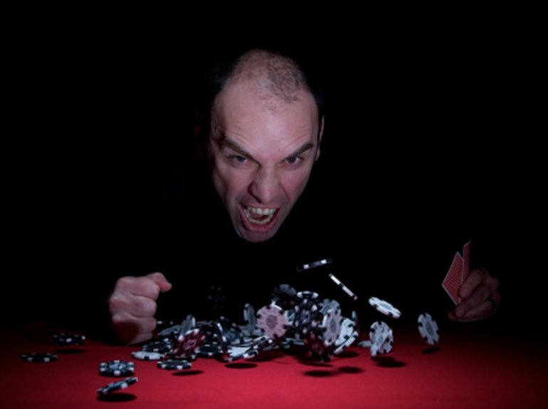 Игрок в агресии стучит по столу, с которого подлетают фишки